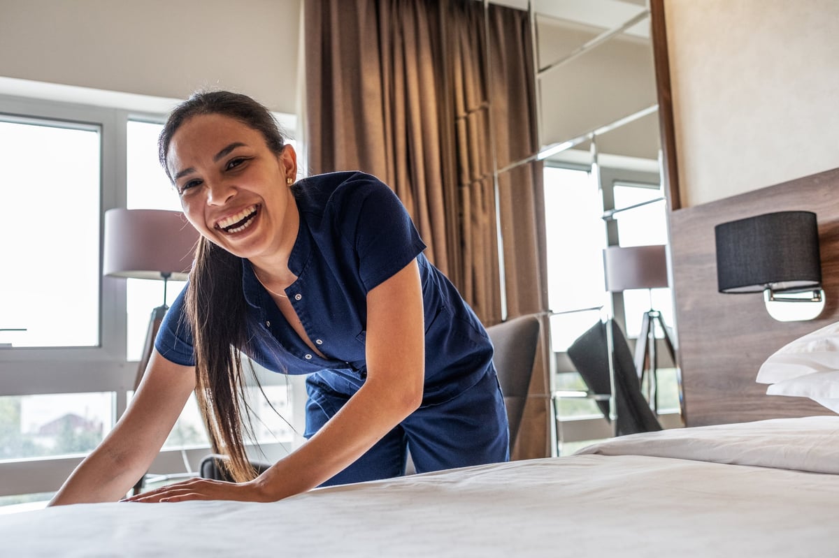 Eine Hotelperson bereitet ein Zimmer für die nächsten Gäste vor