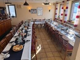 Langer Banketttisch mit Platzierungen und Speisen in einem Restaurant mit Kronleuchtern