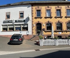 Reihe bunter historischer Gebäude mit Geschäften und geparktem Auto in einer Stadtstraße